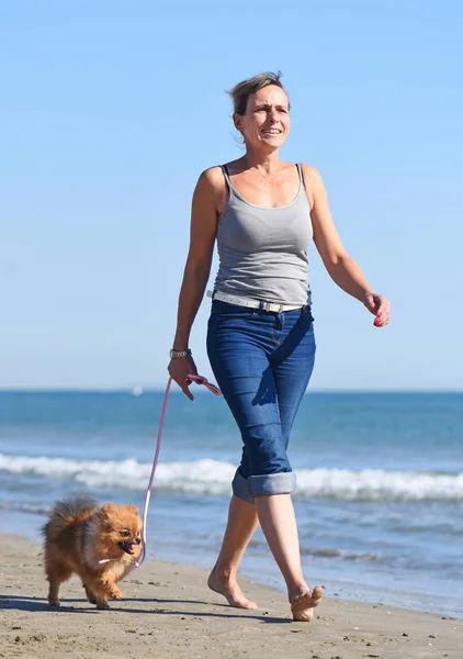 Mulher e cão na praia — Fotografia de Stock