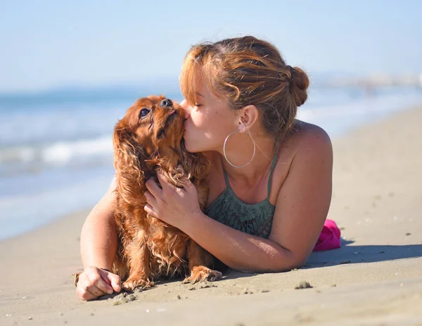 Vrouw en hond op het strand — Stockfoto