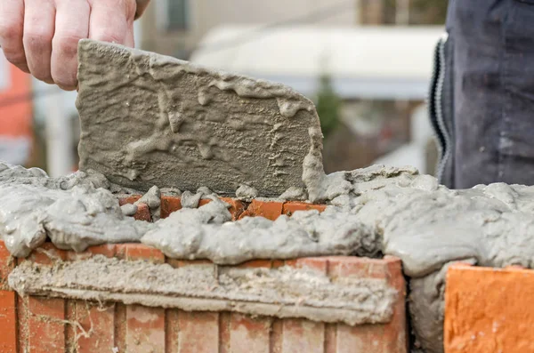 Murare arbetare installera tegel murverk på ytterväggen — Stockfoto