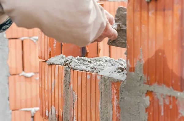 Trabajador albañil instalando mampostería de ladrillo en la pared exterior — Foto de Stock