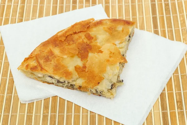 Burek ou torta com queijo e cogumelos em um papel seviettes — Fotografia de Stock