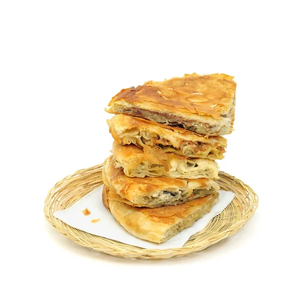 Variedad de sabor Pila de burek crujiente o pasteles en una servilleta de papel en una canasta de mimbre o pan sobre fondo blanco — Foto de Stock