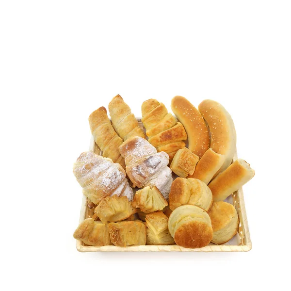 Assortiment varié de pâtisseries cuites dans un panier d'osier ou de pain sur fond blanc — Photo