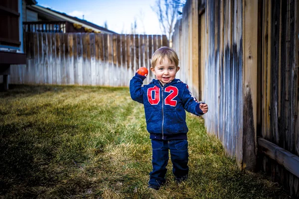 İki 1/2 yıl yaşlı yürümeye başlayan çocuk bahçesinde topuyla oynamaya
