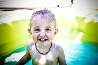 Çocuk yürümeye başlayan çocuk havuzunda oynayan