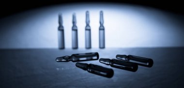 Üzerinde mavi arka plan izole enjeksiyon için tıbbi ampul