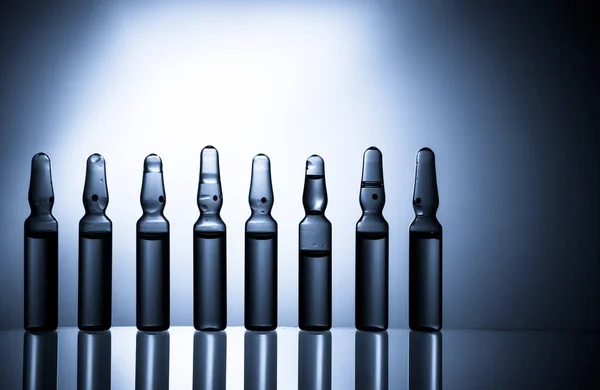 Ampollas médicas inyectables aisladas sobre fondo azul — Foto de Stock