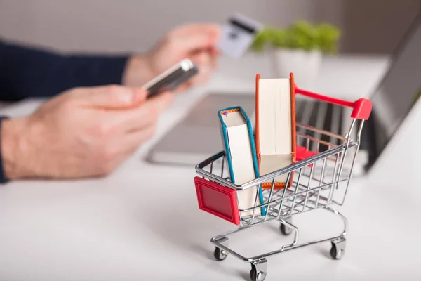  Bir dizüstü bilgisayar ve mini alışveriş at arabası beyaz backg yakın banka kartı