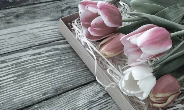 Tulips bunch on dark barn wood planks background