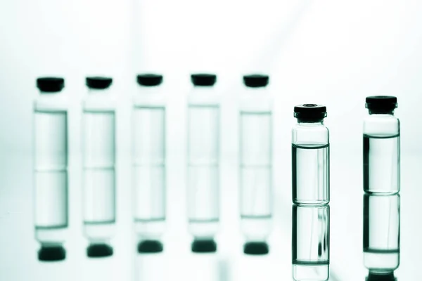 Grupo de ampollas con un medicamento transparente en laboratorio médico — Foto de Stock