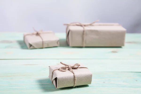 Cajas de regalo envueltas papel kraft atado con cordel y copo de nieve de papel y atado con cordel . — Foto de Stock