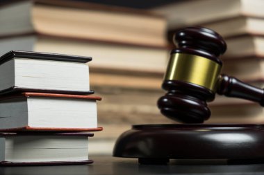 Yargıç tokmak yanında yığın kitap ahşap arka plan üzerinde