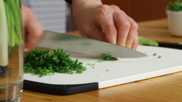 Подрібнення зеленої цибулі на обробній дошці — стокове відео