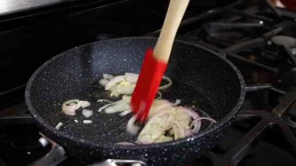 フライパンで白玉ねぎを炒めるシェフ. — ストック動画