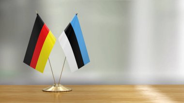 Estonya ve Almanya 'nın bayrak çifti çözülmüş arka plan üzerinde bir masada 