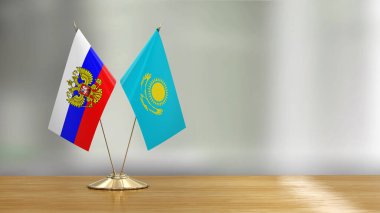 Kazak ve Rus bayrak çifti çözülmüş arka planda bir masada 