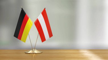 Mikrofonlar ve bayraklar, odaklanmamış arka planda bir masanın üzerinde.