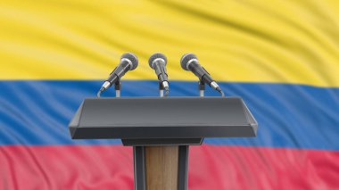 Kürsüde mikrofonlar ve arka planda Kolombiya Bayrağı