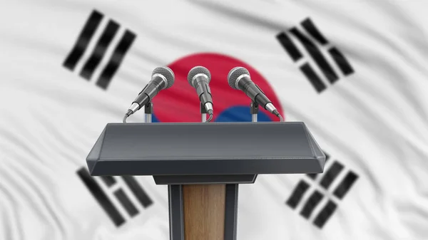 Podium lectern with microphones and South Korean flag in background