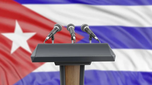 Podium lectern with microphones and Cuban Flag in background