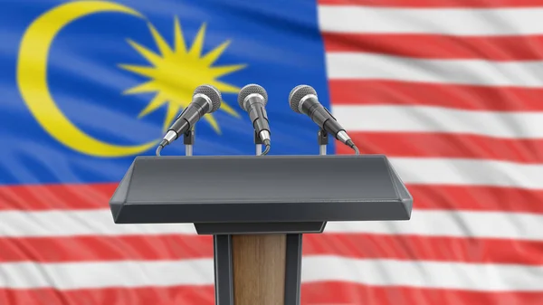 Podium lectern with microphones and Malaysia flag in background