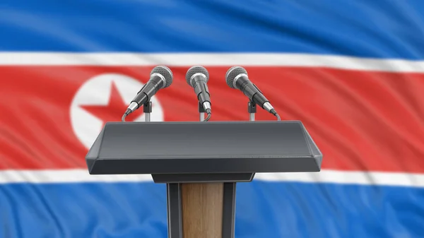 Podium lectern with microphones and North Korean Flag in background