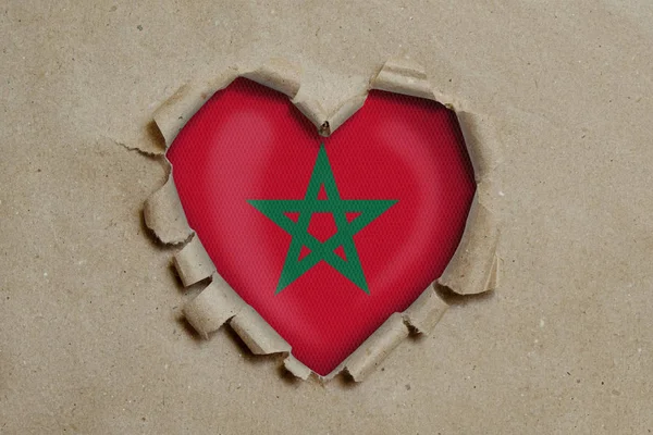 紙を通して引き裂かれたハート型の穴モロッコ国旗を示す — ストック写真