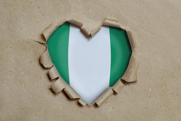 Dziura Kształcie Serca Rozdarta Przez Papier Pokazująca Nigeryjską Flagę — Zdjęcie stockowe