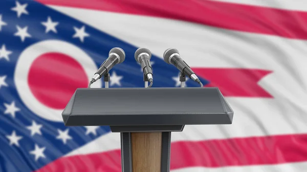 Podium lectern with microphones and Ohio flag in background