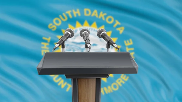 Podium lectern with microphones and South Dakota flag in background