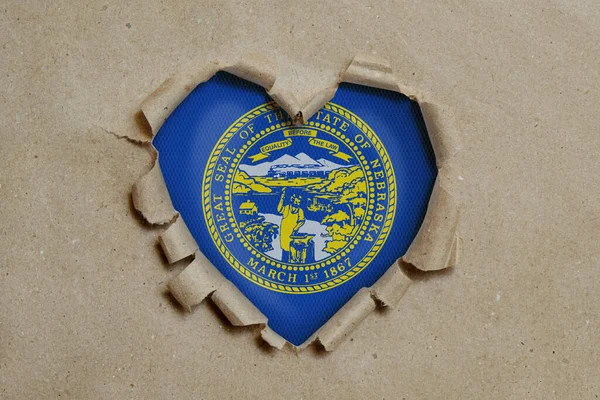 Heart Shaped Hole Torn Paper Showing Nebraska Flag — Stock Photo, Image