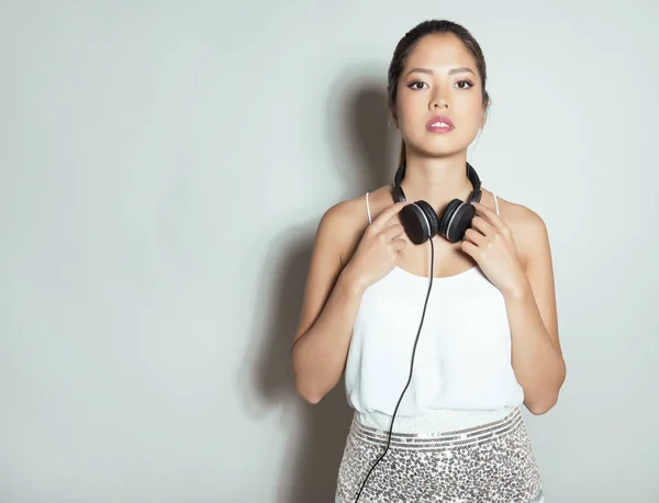 Vacker asiatisk kvinna med hörlurar — Stockfoto