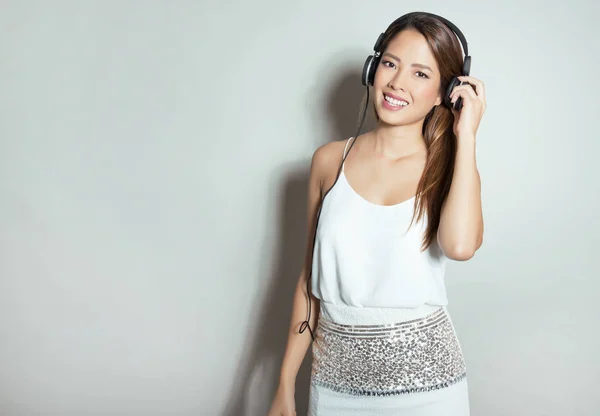 Mulher asiática bonita com fones de ouvido — Fotografia de Stock