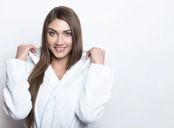 Mooie jonge vrouw in badjas — Stockfoto