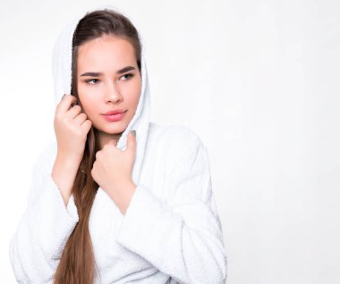 Uzun saçlı, beyaz bornoz giyen güzel bir genç kadın.