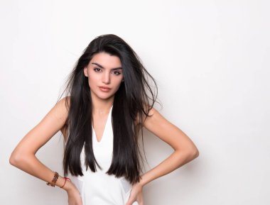 Uzun siyah saçlı, beyaz elbiseli güzel bir kadın.