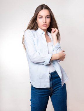 Uzun kahverengi saçlı, kol saati takan güzel bir genç kadın.