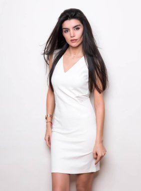 Uzun siyah saçlı, beyaz elbiseli güzel bir kadın.