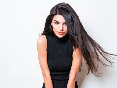 elbise ve beyaz arka plan üzerinde poz uzun siyah saçlı güzel genç kadın