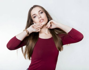 Uzun kahverengi saçlı, kol saati takan güzel bir genç kadın.