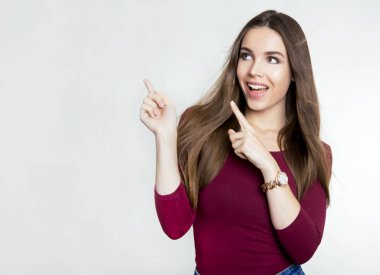 Uzun kahverengi saçlı, kol saati takan güzel bir genç kadın.