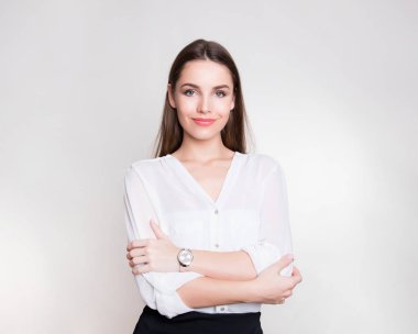 Uzun kahverengi saçlı, kol saati takan güzel bir genç kadın.