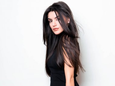 elbise ve beyaz arka plan üzerinde poz uzun siyah saçlı güzel genç kadın