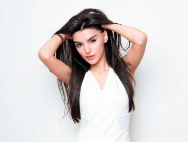 elbise ve beyaz arka plan üzerinde poz uzun siyah saçlı güzel genç kadın