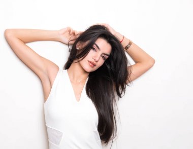 elbise ve beyaz arka plan üzerinde poz uzun siyah saçlı güzel genç kadın