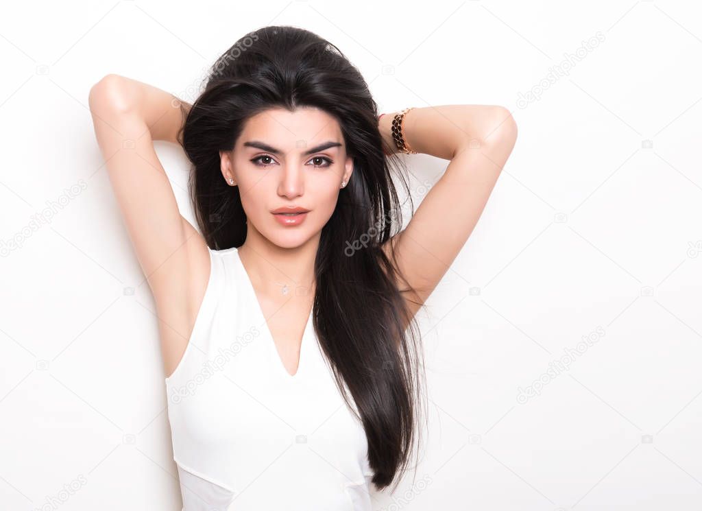 beautiful young woman with long black hair wearing dress and posing on white background