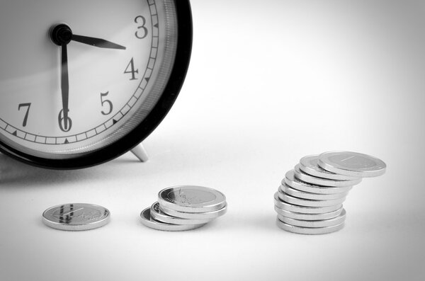 alarm clock with stack of coins
