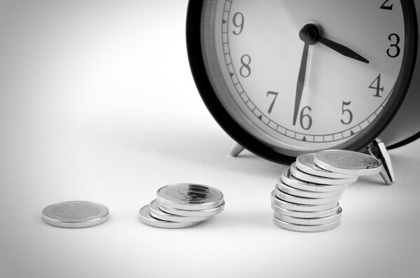 alarm clock with stack of coins