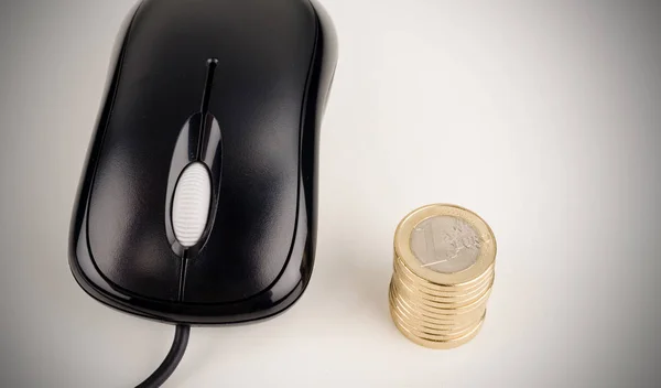 コンピューターのマウスとコインのスタック — ストック写真
