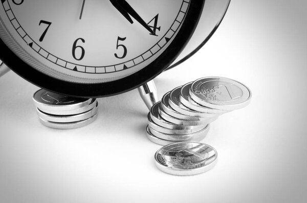 pile of coins near alarm clock